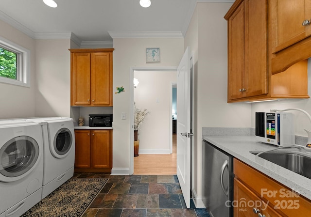 clothes washing area with independent washer and dryer, a sink, baseboards, stone finish flooring, and ornamental molding