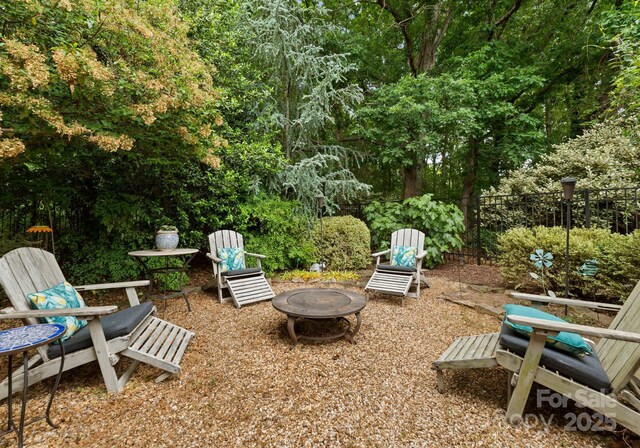 view of yard with an outdoor fire pit and fence