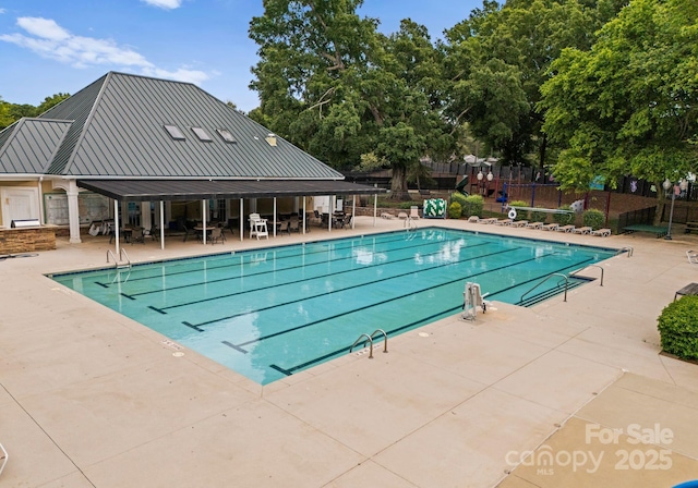 pool with a patio and fence