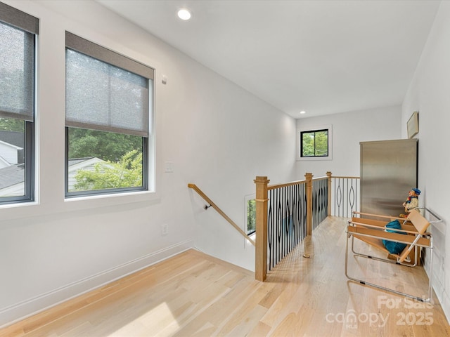 staircase featuring baseboards, wood finished floors, and recessed lighting