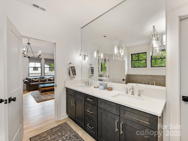 bathroom with a chandelier, a sink, and plenty of natural light