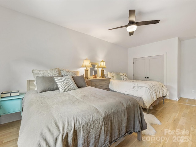 bedroom featuring a ceiling fan, a closet, and light wood-style flooring