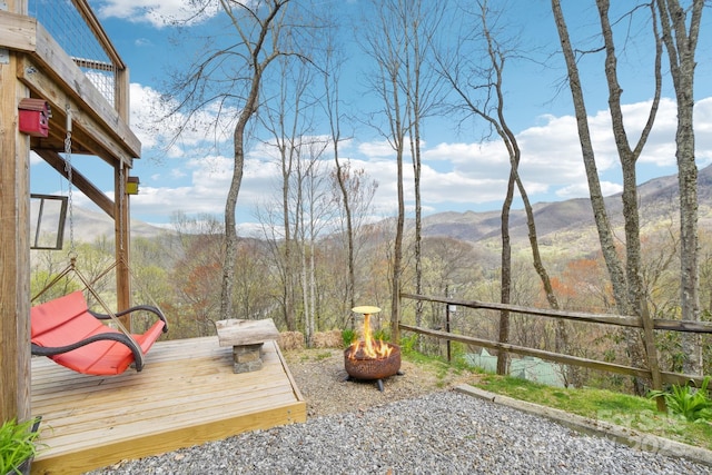 view of yard featuring a fire pit and a deck with mountain view