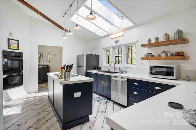 39 Tatham Rd, Hendersonville, NC 28792 - kitchen featuring blue cabinets, stainless steel appliances, a sink, light wood-style floors, and a kitchen island