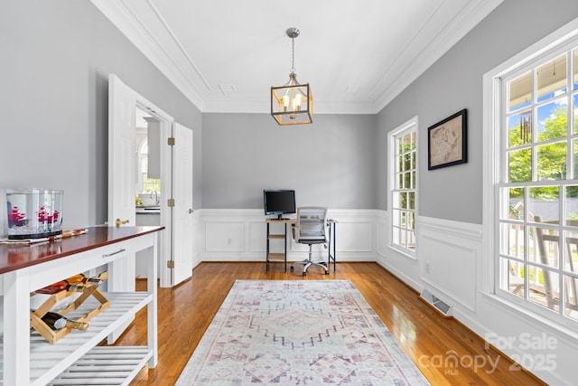 home office with wood finished floors, a chandelier, wainscoting, visible vents, and crown molding
