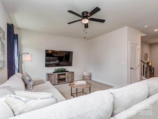 carpeted living room featuring baseboards and ceiling fan