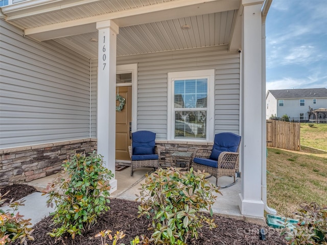 view of patio featuring fence and covered porch