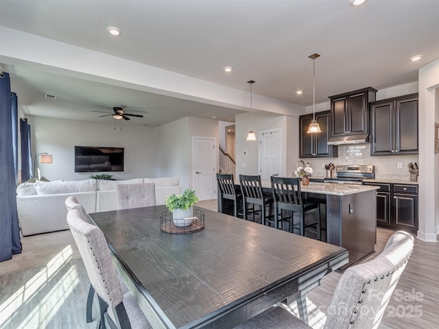 dining space with recessed lighting, light wood finished floors, stairway, and a ceiling fan