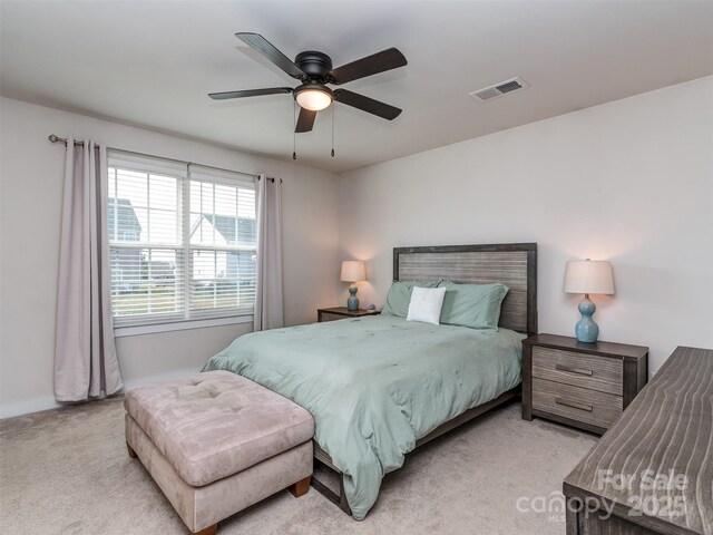 bedroom with ceiling fan, light carpet, visible vents, and baseboards