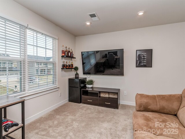 living room featuring recessed lighting, visible vents, baseboards, and light carpet