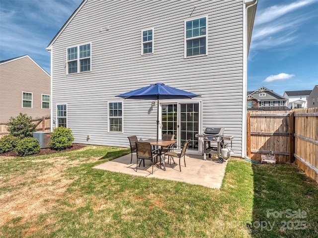 rear view of property featuring central AC, fence, a yard, and a patio