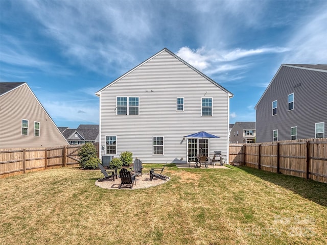 rear view of house with a lawn, a fenced backyard, an outdoor fire pit, and a patio