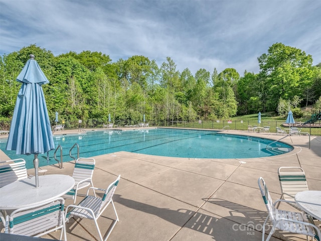 community pool featuring a patio and fence