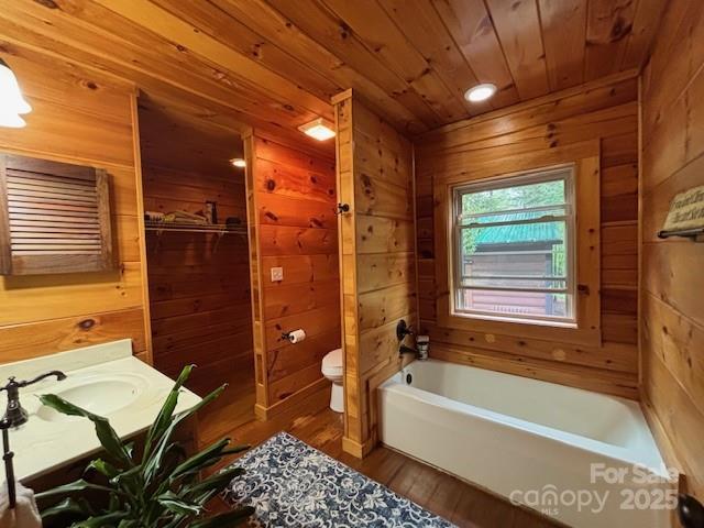 926 Cross Creek Dr, Rutherfordton, NC 28139 - bathroom with wooden walls, toilet, wooden ceiling, wood finished floors, and a tub to relax in
