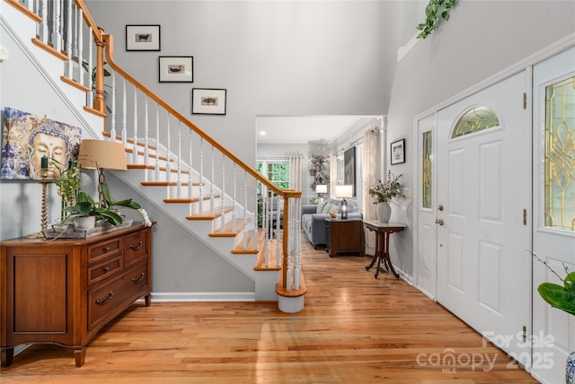 148 Broyles Rd, Hendersonville, NC 28791 - entryway with light wood-style floors, stairway, a high ceiling, and baseboards