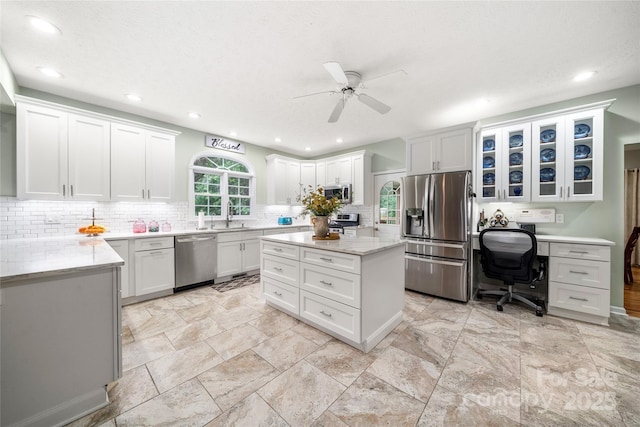 148 Broyles Rd, Hendersonville, NC 28791 - kitchen featuring appliances with stainless steel finishes, a ceiling fan, backsplash, a sink, and white cabinets