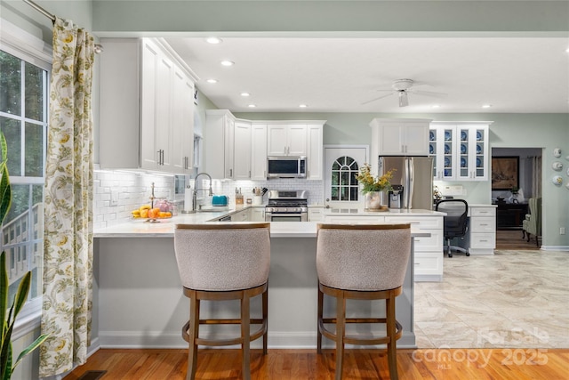 148 Broyles Rd, Hendersonville, NC 28791 - kitchen with stainless steel appliances, a peninsula, backsplash, glass insert cabinets, and a desk