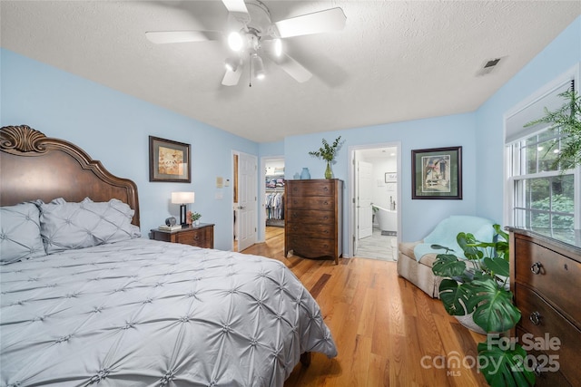 148 Broyles Rd, Hendersonville, NC 28791 - bedroom featuring light wood-style floors, a textured ceiling, ensuite bath, and ceiling fan