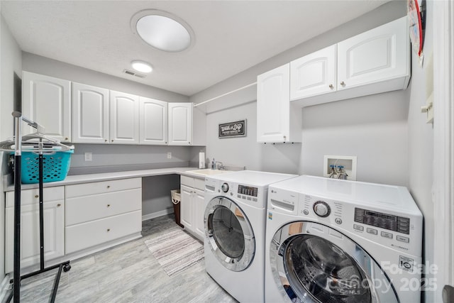 148 Broyles Rd, Hendersonville, NC 28791 - laundry room featuring washer and dryer, cabinet space, and light wood-style flooring