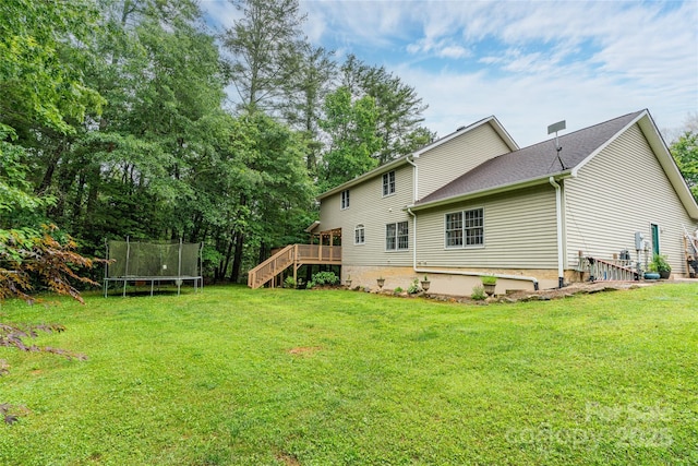 148 Broyles Rd, Hendersonville, NC 28791 - back of house featuring a trampoline, stairway, a wooden deck, and a yard