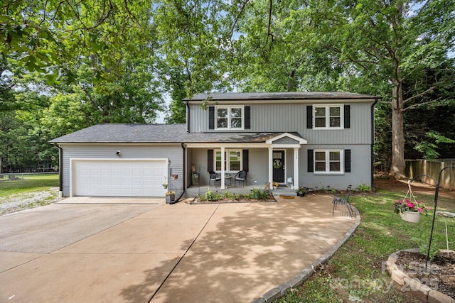 130 Cherokee Ln, Salisbury, NC 28147 - traditional home featuring covered porch, an attached garage, concrete driveway, roof with shingles, and view of wooded area
