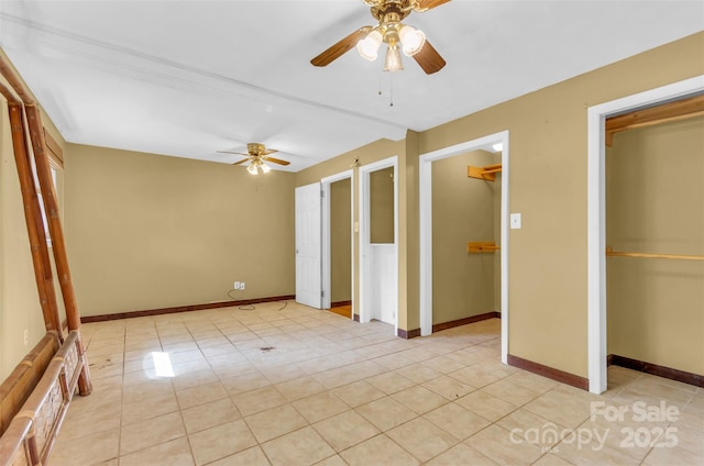 interior space featuring light tile patterned floors, baseboards, and ceiling fan