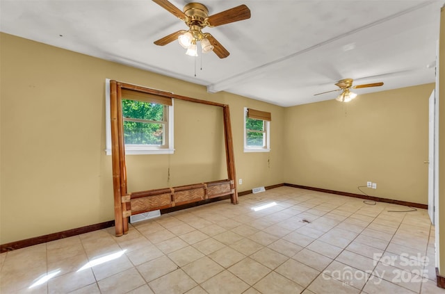 unfurnished room with baseboards, ceiling fan, and light tile patterned flooring