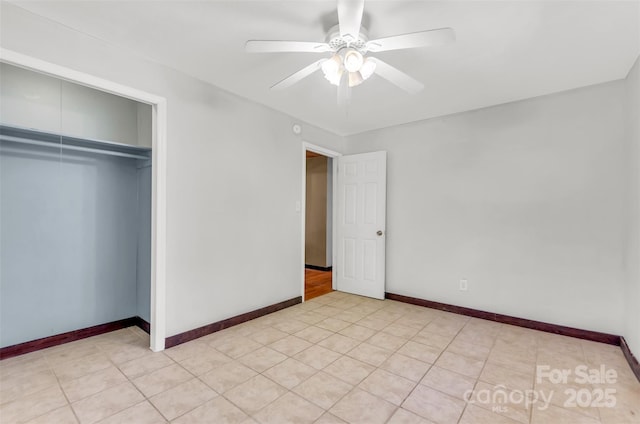 unfurnished bedroom with a ceiling fan, baseboards, light tile patterned floors, and a closet