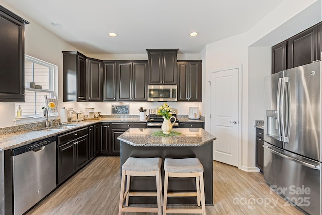 176 Jennymarie Rd, Mooresville, NC 28115 - kitchen with appliances with stainless steel finishes, a sink, light stone counters, a kitchen island, and light wood finished floors