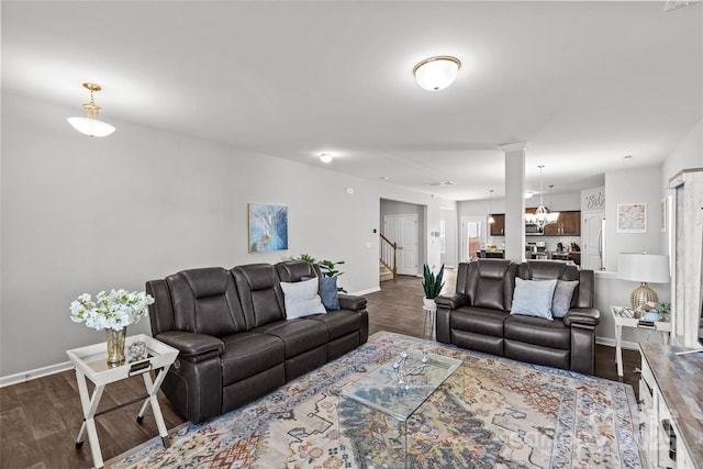 living area featuring baseboards, dark wood-type flooring, and stairs
