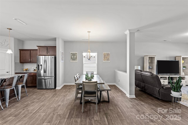 dining area featuring dark wood finished floors, baseboards, and a chandelier