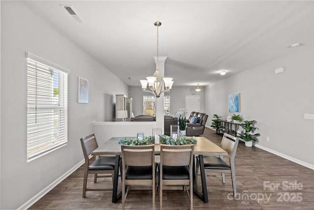 dining area featuring wood finished floors, baseboards, and a chandelier