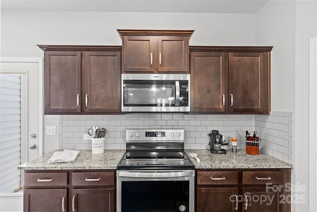 kitchen featuring appliances with stainless steel finishes, dark brown cabinetry, tasteful backsplash, and light stone counters