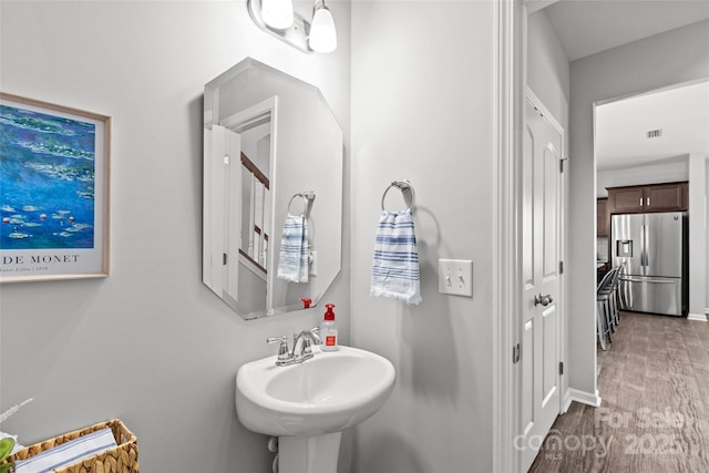 bathroom featuring a sink, wood finished floors, and baseboards
