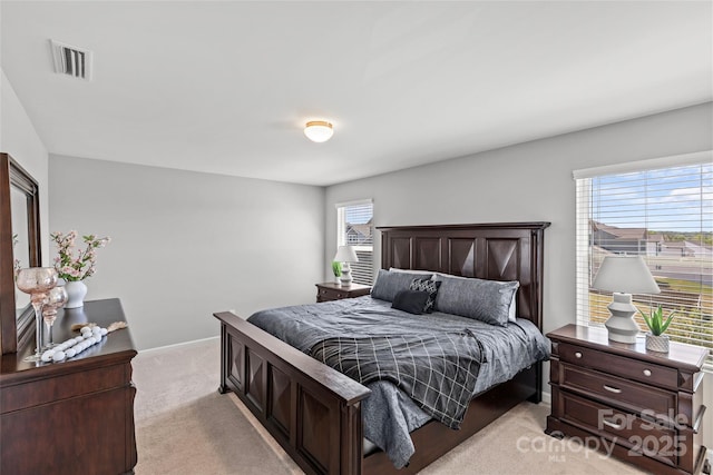 bedroom featuring light colored carpet, multiple windows, and baseboards