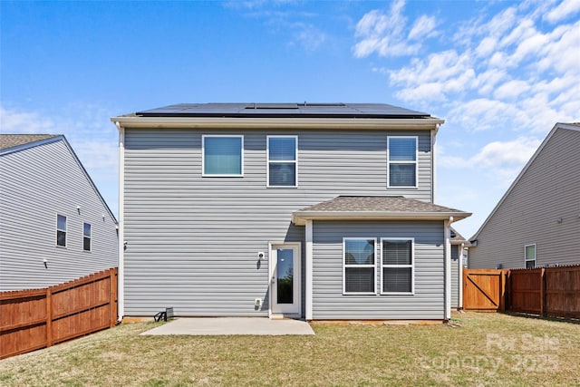 back of house with solar panels, a patio, and a gate