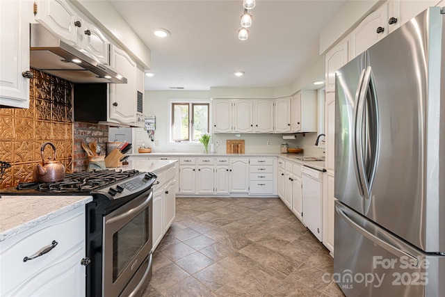 kitchen featuring white cabinets, under cabinet range hood, a sink, decorative backsplash, and appliances with stainless steel finishes