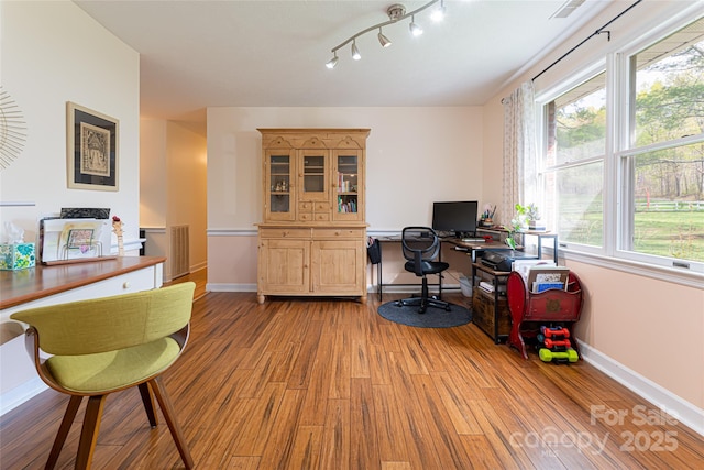 office space with light wood-style flooring, visible vents, and baseboards