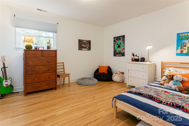 bedroom featuring light wood finished floors, baseboards, and visible vents