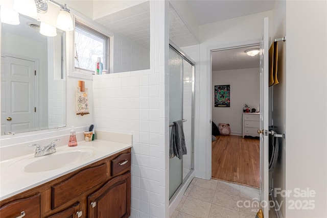 full bath featuring vanity, tile patterned flooring, and a stall shower