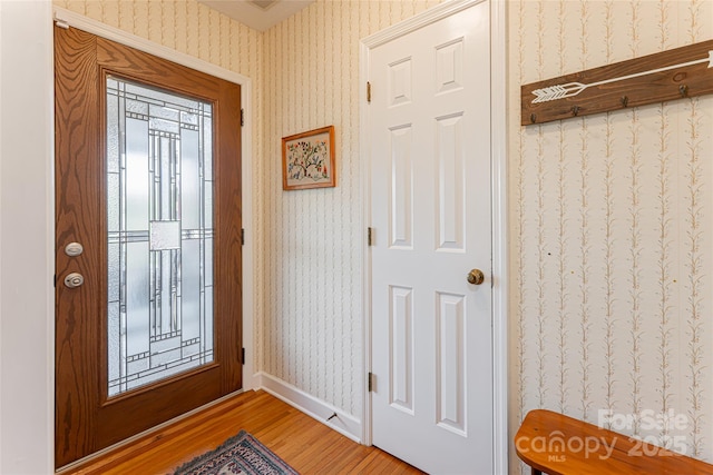 entrance foyer with baseboards, light wood-style floors, and wallpapered walls