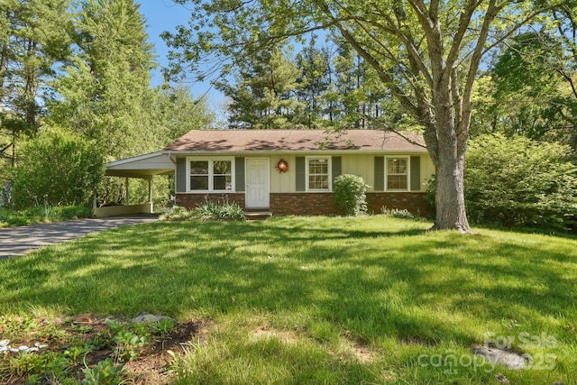 ranch-style home featuring brick siding, a front lawn, driveway, and a carport