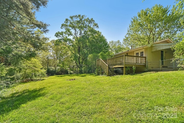 view of yard with a wooden deck and stairs