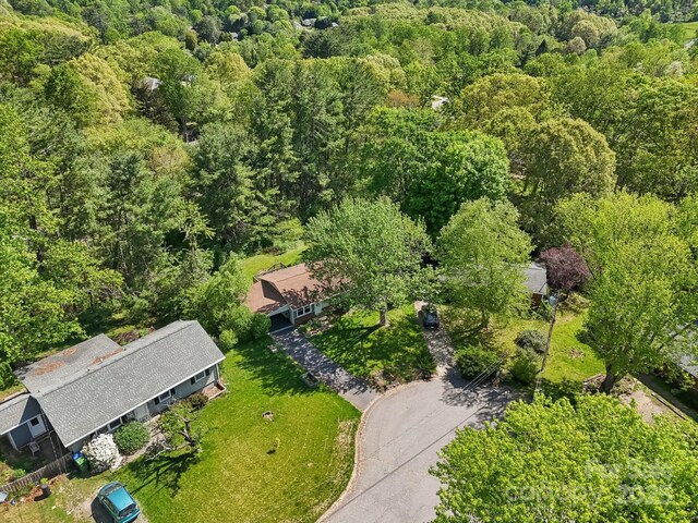 drone / aerial view with a wooded view