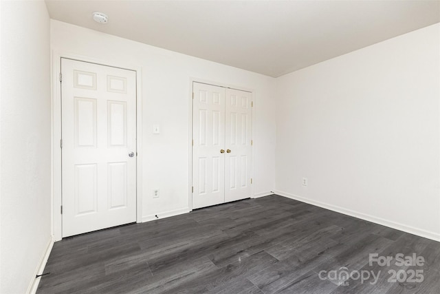 8424 Spirea Ct, Charlotte, NC 28215 - unfurnished bedroom with dark wood-style flooring, a closet, and baseboards