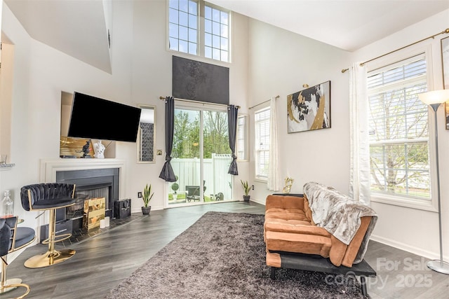 8424 Spirea Ct, Charlotte, NC 28215 - living area featuring a fireplace with flush hearth, a towering ceiling, wood finished floors, and baseboards