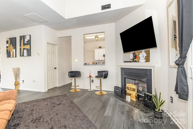 8424 Spirea Ct, Charlotte, NC 28215 - living room featuring a fireplace with raised hearth, visible vents, wood finished floors, and baseboards