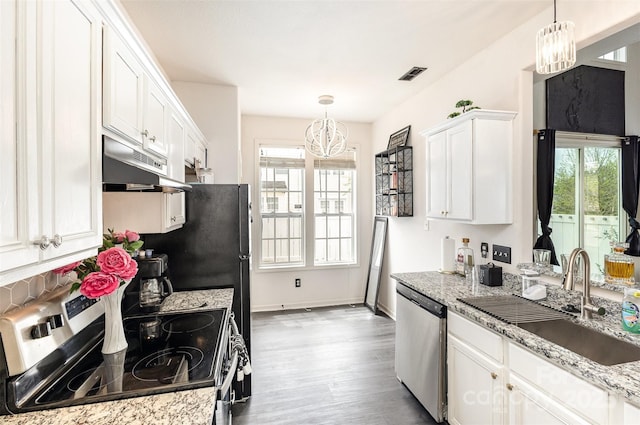 8424 Spirea Ct, Charlotte, NC 28215 - kitchen with a sink, a chandelier, stainless steel appliances, visible vents, and under cabinet range hood