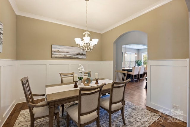 505 Chamberlain Ct, Mcadenville, NC 28101 - dining space with crown molding, a notable chandelier, a decorative wall, arched walkways, and a wainscoted wall