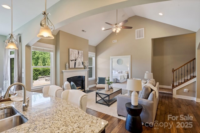 505 Chamberlain Ct, Mcadenville, NC 28101 - living area featuring a glass covered fireplace, dark wood finished floors, stairs, a ceiling fan, and visible vents
